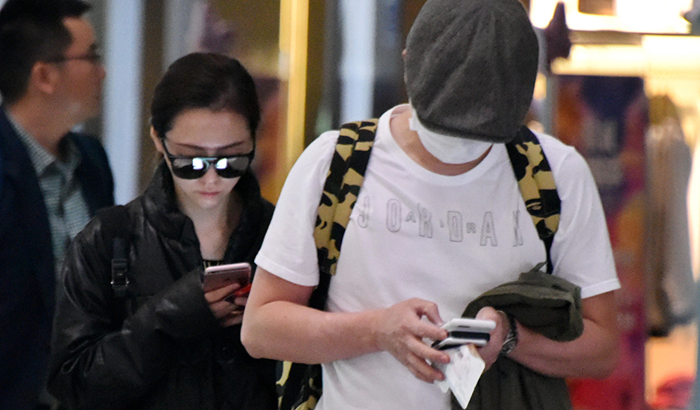张靓颖冯轲现身机场 一路玩手机变无交流